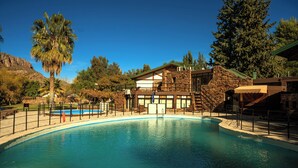 Une piscine avec un bâtiment en pierre en arrière-plan.
