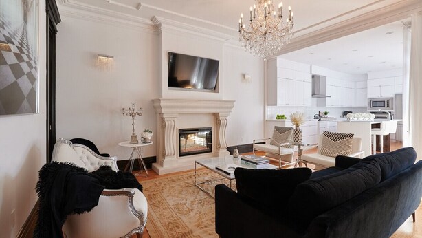 A living room with a fireplace, a television, and a chandelier.