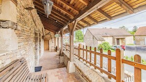 Ein rustikales Steinhaus mit einem Holzbalkon und einem Holzzaun.