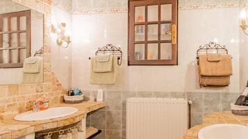 Une salle de bain avec deux lavabos, un plafond en bois et une fenêtre avec un porte-serviettes.