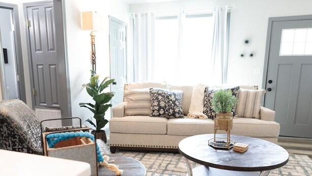 A living room with a beige sofa, two round coffee tables, and a patterned rug.