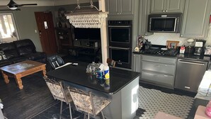 A kitchen with a central island, built-in appliances, and a dining area with a coffee table and chairs. - Old Town 2BD1BA, Pet friendly (Albuquerque)