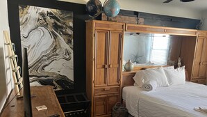 A bedroom with a large wooden wardrobe, a marble wall, a globe, and a bed with white bedding. - Old Town 2BD1BA, Pet friendly (Albuquerque)