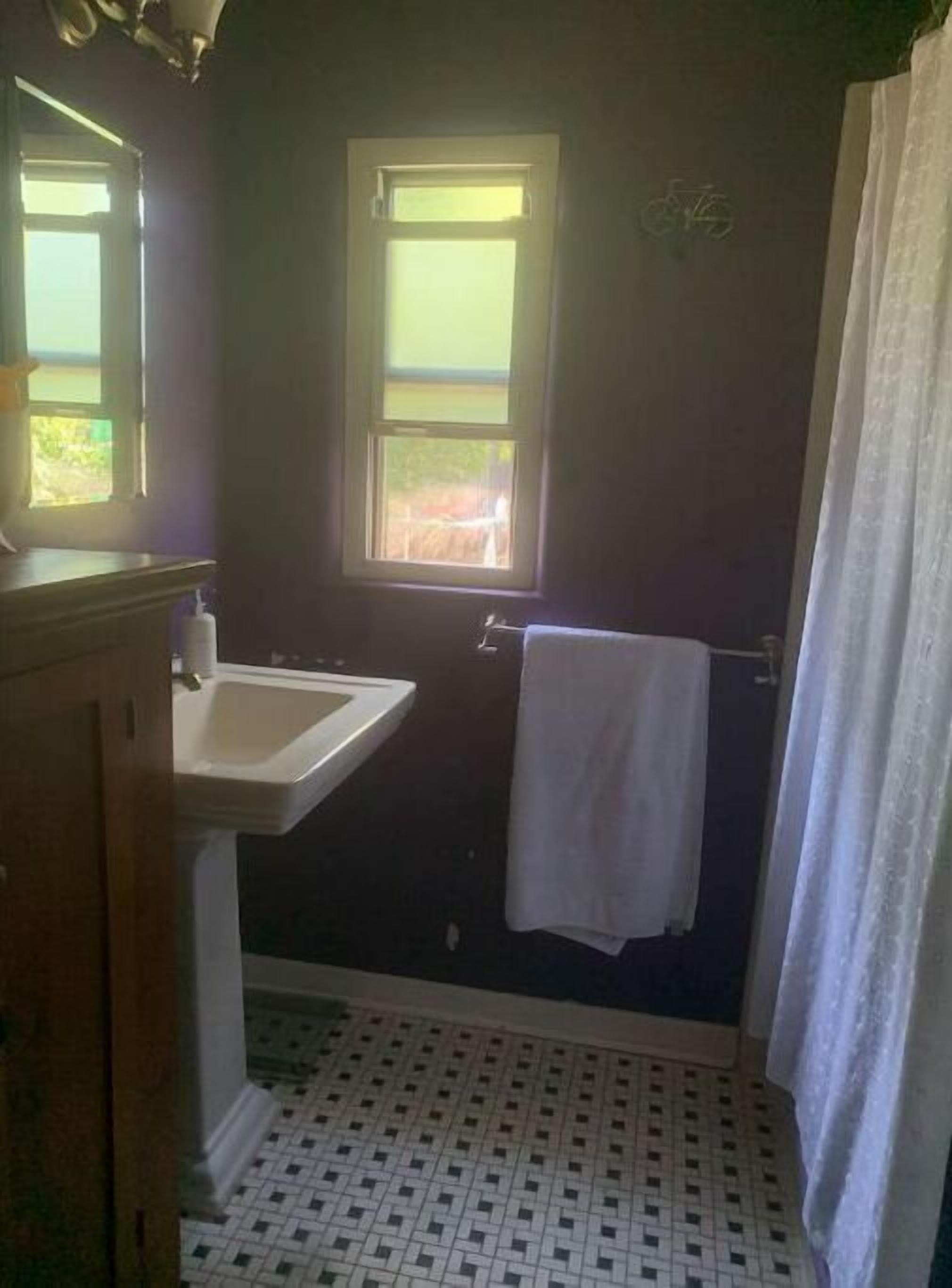 Une salle de bain avec un lavabo, une fenêtre et un porte-serviettes.