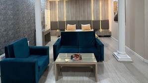 A modern living room with a sofa set, a coffee table, and a lamp. - Empire Hotel (Baku)