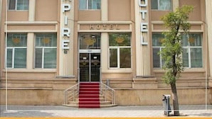 A building with the sign "EMPIRE HOTEL" above the entrance, featuring a grand facade with large windows and a central staircase leading to the door. - Empire Hotel (Baku)