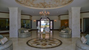 A spacious lobby with a central round table, two sofas, and a chandelier. - Luxury Condo Steps from Ocean with Great Views at The Landmark Resort of Cozumel (San Miguel de Cozumel)