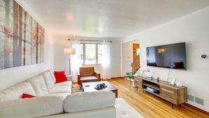 A modern living room with a white sofa, a wooden coffee table, and a TV mounted on the wall. - 3 Mi to Downtown: Pittsburgh Home w/ Balcony! (Pittsburgh)