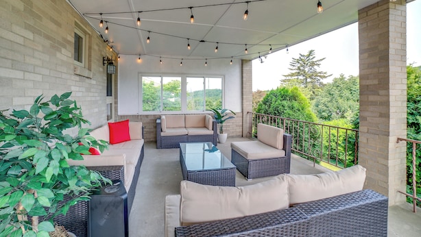 An outdoor patio with wicker furniture, a glass coffee table, and string lights. - 3 Mi to Downtown: Pittsburgh Home w/ Balcony! (Pittsburgh)