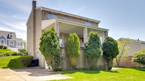 A two-story house with a covered porch, a brick exterior, and a well-maintained lawn. - 3 Mi to Downtown: Pittsburgh Home w/ Balcony! (Pittsburgh)