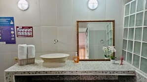 A bathroom with a mosaic-tiled vanity, a round sink, a mirror with a gold frame, and a window with blinds. - San José HOUSE (Leticia)