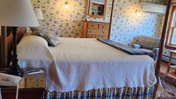 A bedroom with a bed, a dresser, a lamp, and a mirror.