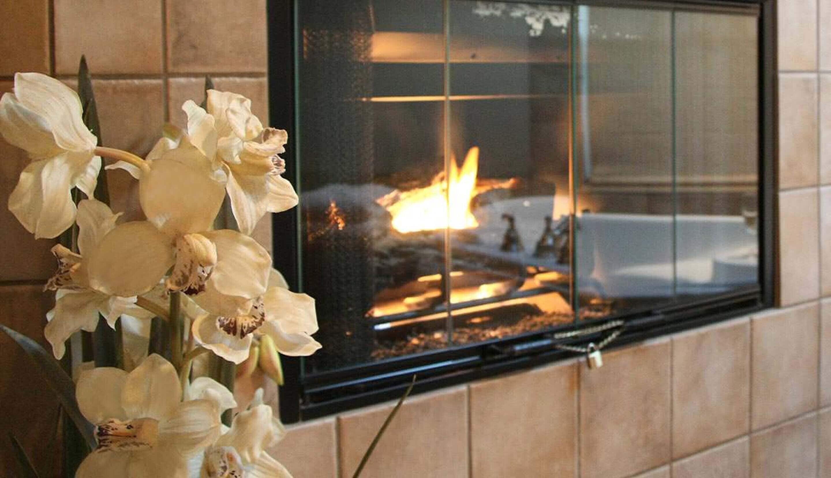 Una ventana con un fuego en su interior, cuyo reflejo se aprecia en el cristal.