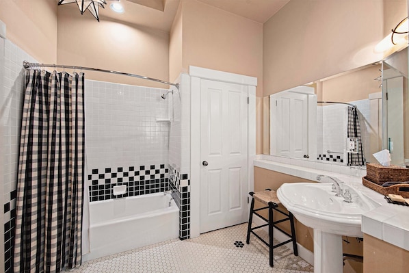 Un baño con una bañera blanca, un lavabo y un espejo.