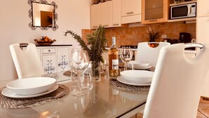 Un comedor moderno con una mesa de cristal, sillas blancas y un centro de mesa decorativo.