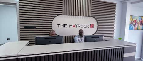 A reception desk with a modern design, featuring a logo and a nameplate.
