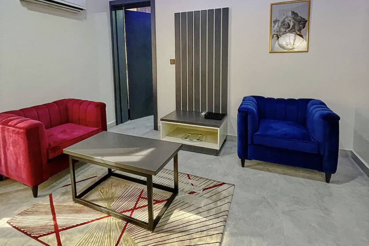 Una sala de estar moderna con dos sofás, una mesa de centro y un tapiz decorativo.