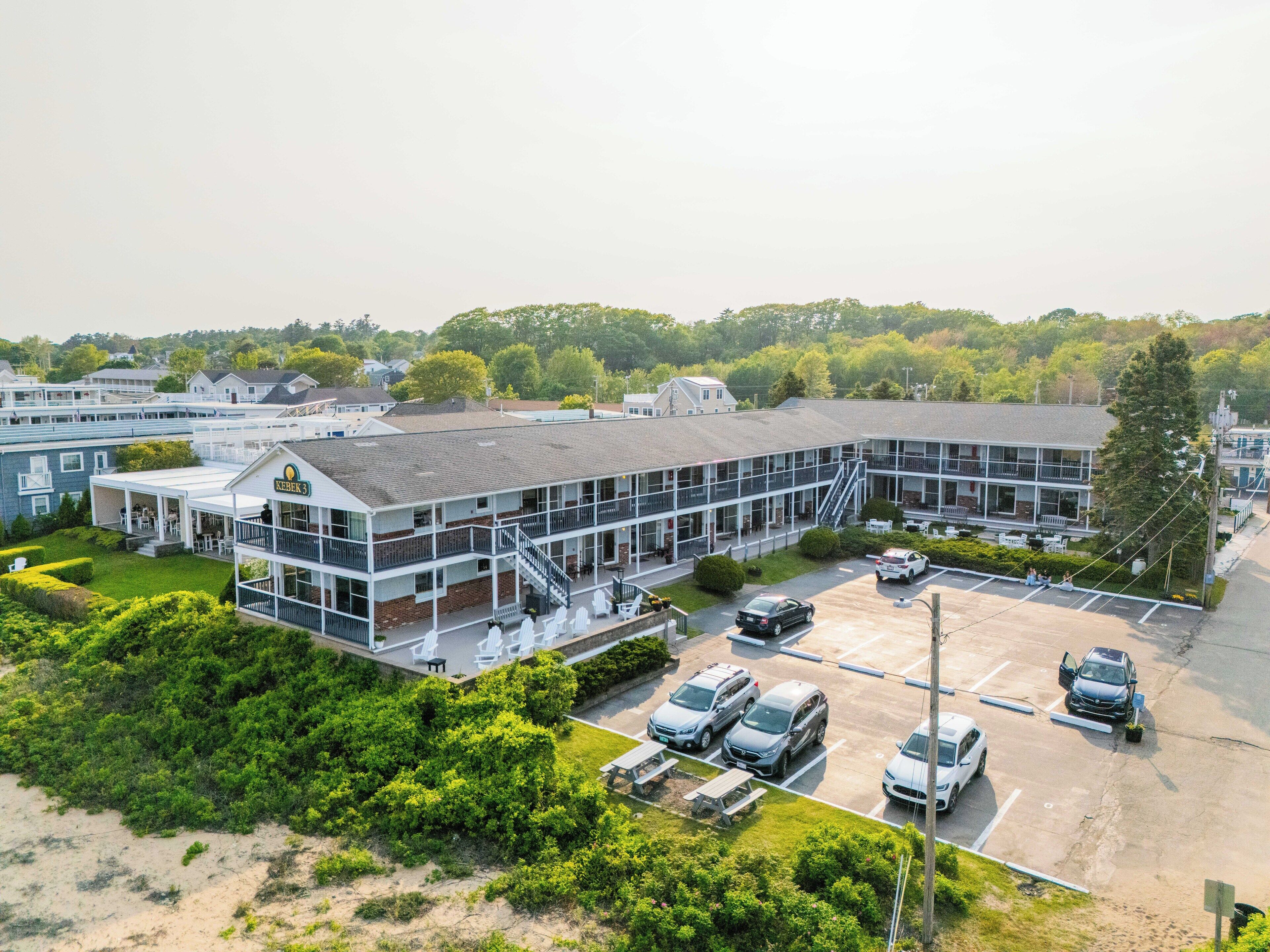 Un hôtel à plusieurs étages doté d’un espace extérieur couvert, d’un parking et offrant une vue sur la végétation environnante.
