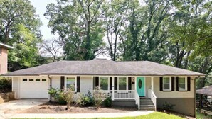 A single-story house with a front porch, a garage, and a well-maintained lawn.