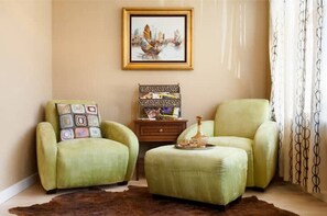 Cozy living room with two armchairs, a side table, and a framed artwork.