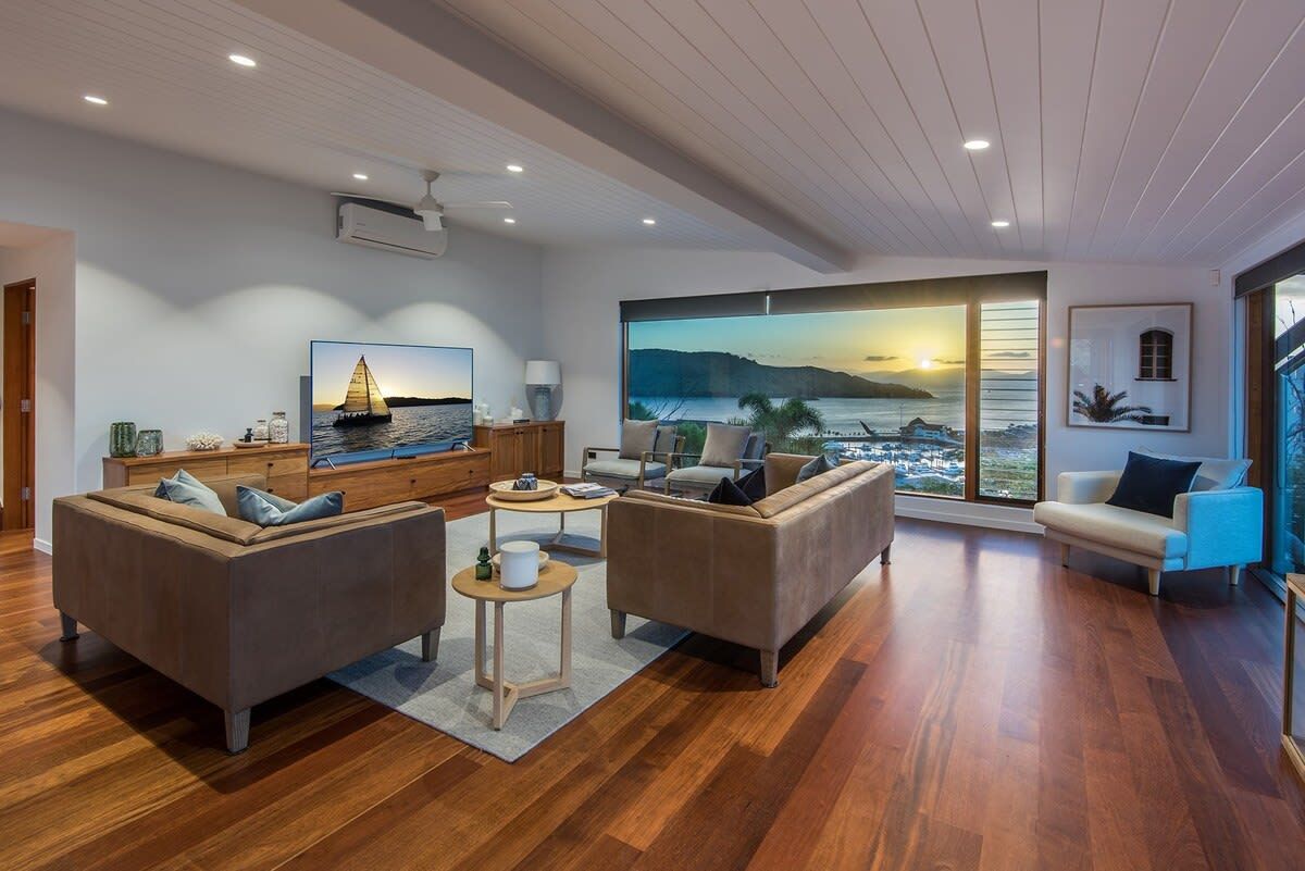 A modern living room with a large window, a sofa set, a coffee table, and a television.