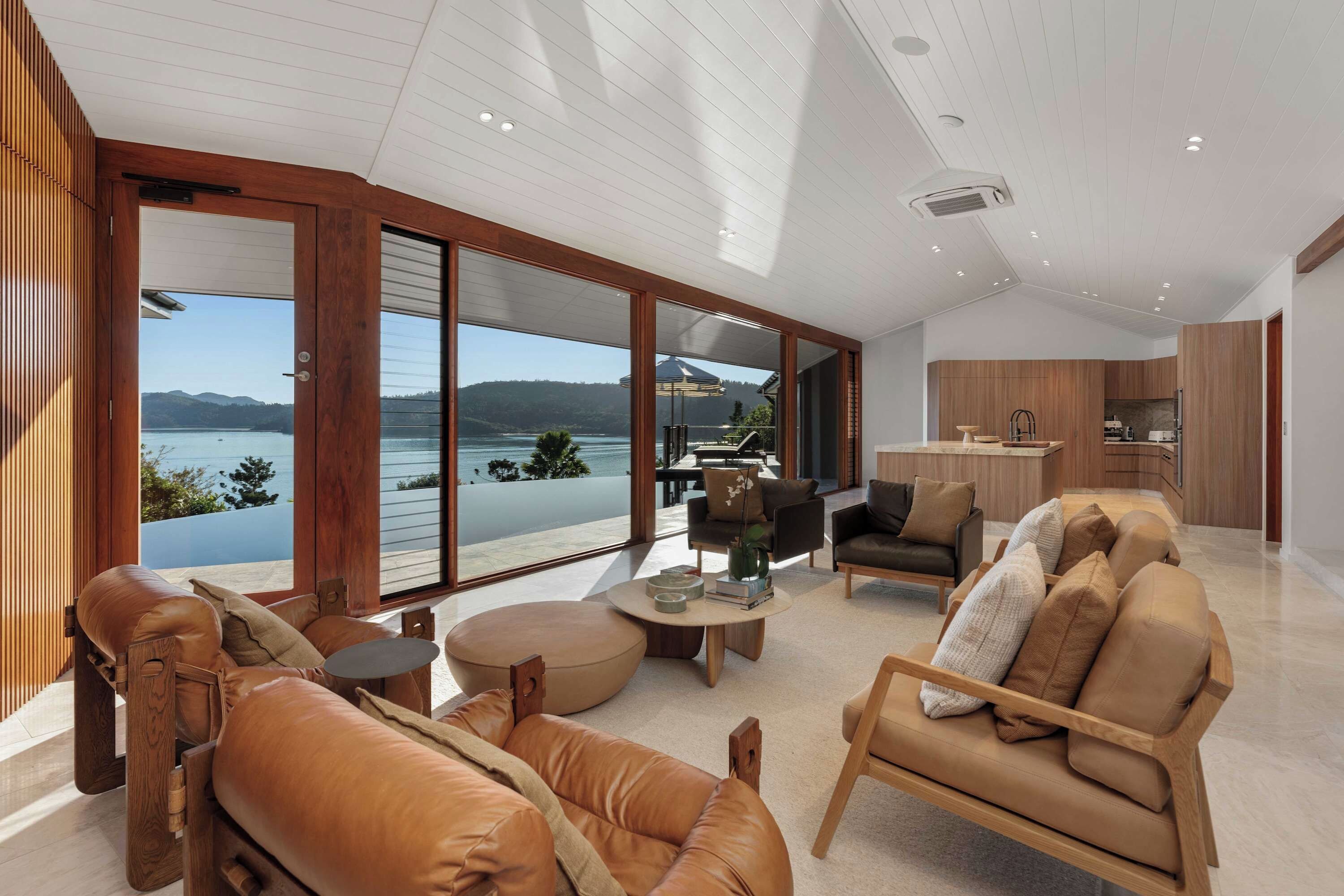 A spacious living area with a large sliding glass door leading to a balcony with a lake view.