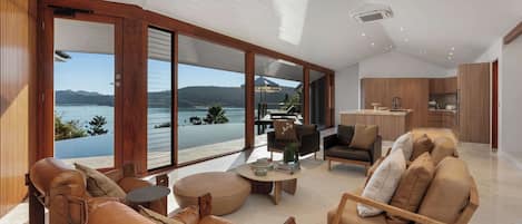A spacious living area with a large sliding glass door leading to a balcony with a lake view.