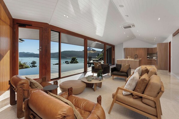 A spacious living area with a large sliding glass door leading to a balcony with a lake view.