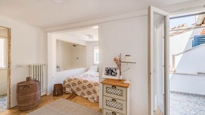 A bedroom with a bed, a dresser, a radiator, and a window. - Apartments Florence - Sprone Terrace (Firenze)