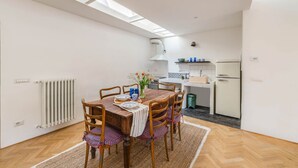 A compact kitchen with a dining area, a skylight, and a radiator. - Apartments Florence - Sprone Terrace (Firenze)