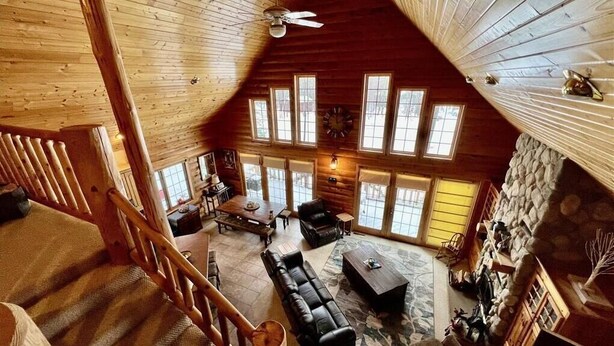 A spacious loft-style living area with a high ceiling, large windows, and a cozy fireplace. - Little Cottage On Prairie - Prairie Lake That Is!!! (Cameron)