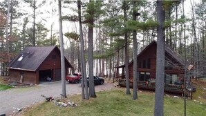 A cabin with a garage, surrounded by tall trees. - Little Cottage On Prairie - Prairie Lake That Is!!! (Cameron)