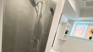 Une salle de bain moderne avec une douche à parois de verre, un lavabo blanc et des toilettes.
