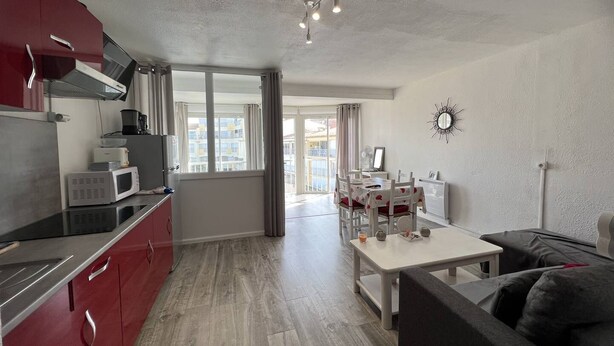 A modern apartment with a kitchen, dining area, and living room. - AGREABLE DEUX PIECES RENOVE DANS UNE RESIDENCE AVEC PISCINE (LE CAP D AGDE)