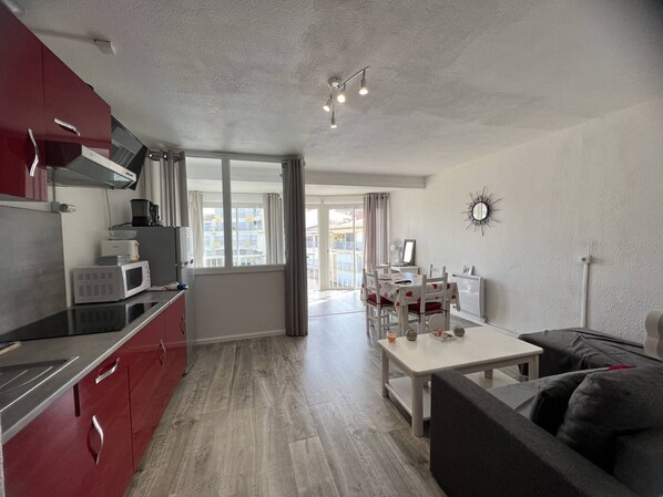 A modern apartment with a kitchen, dining area, and living room.