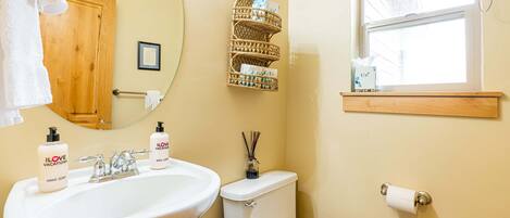 Un baño con lavamanos, inodoro y ventana.