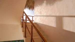 Un escalier avec des rampes en bois et des marches blanches, menant à un niveau supérieur.