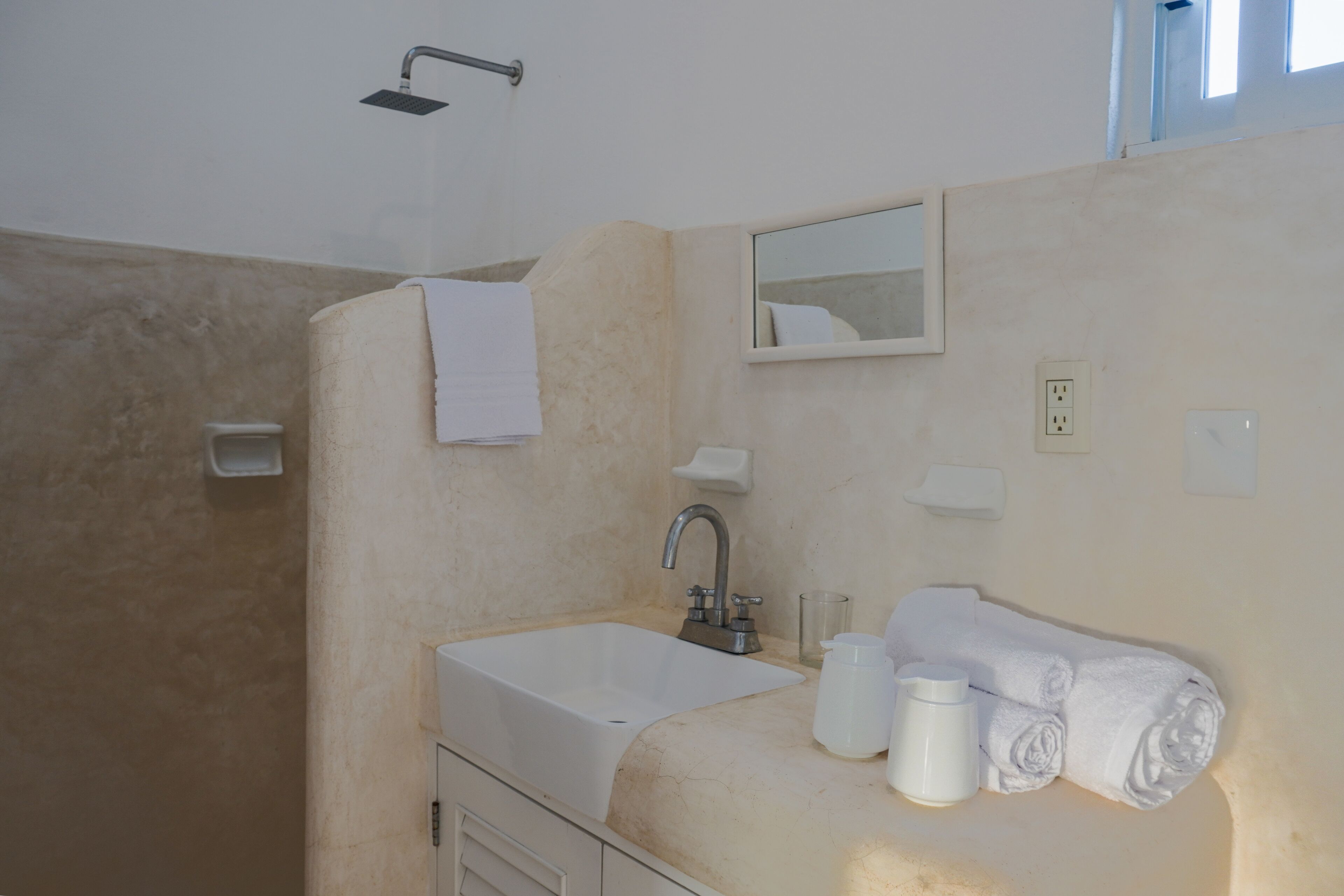 A bathroom with a bathtub, a sink, a mirror, and a towel rack.