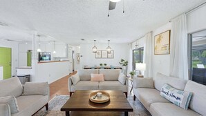 A modern living room with a sofa set, a coffee table, and a dining area with a table and chairs.