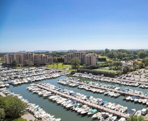 A marina with numerous boats docked, surrounded by apartment buildings and greenery. - Elegant Studio With Marina Sea And Esterel View (Mandelieu-la-Napoule)