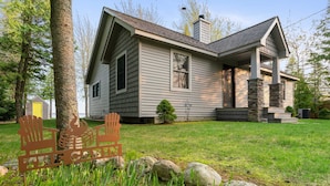 A two-story house with a stone chimney, a front porch, and a small shed in the background. - Northern Tranquility on Black Lake
Available the weeks of July 11 and July 18!!! (Cheboygan)