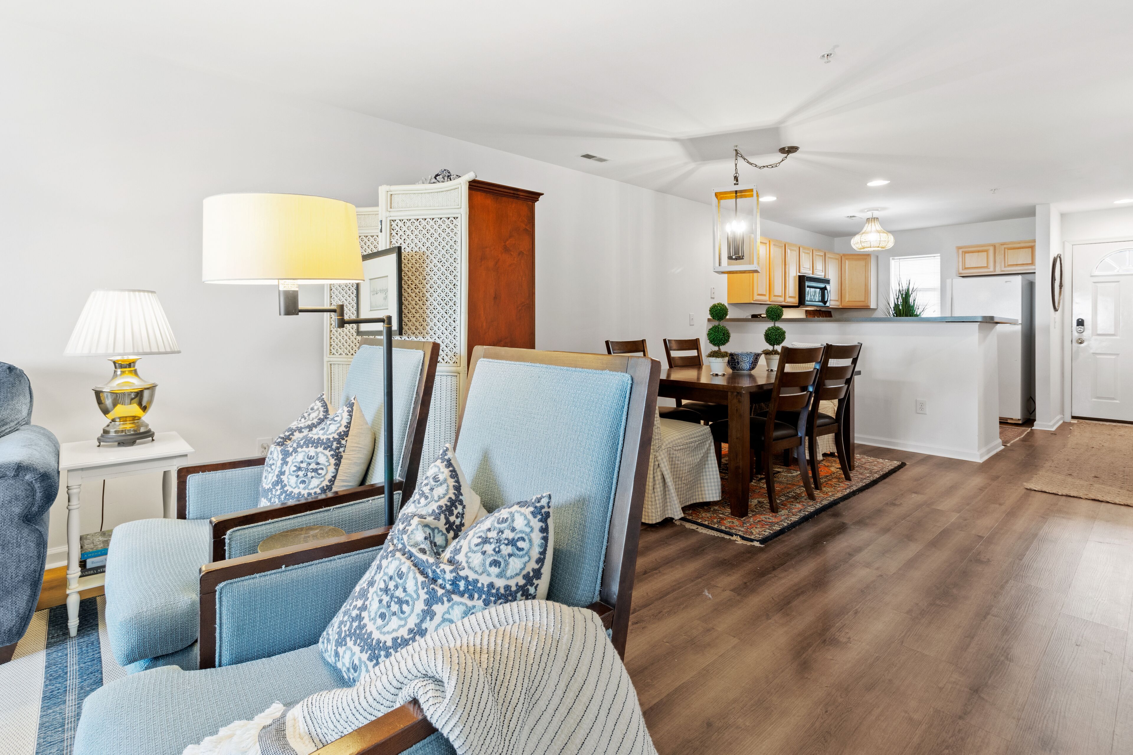 Ein modernes Wohnzimmer mit Essbereich, Holzboden und einer Küche im Hintergrund.
