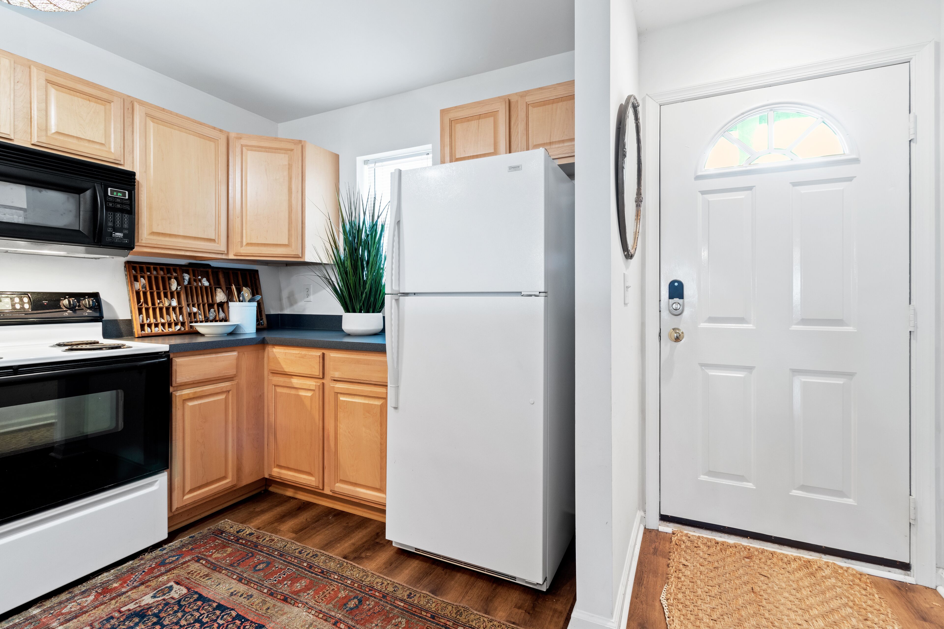 A kitchen with wooden cabinets, a white refrigerator, a microwave, and a stove.