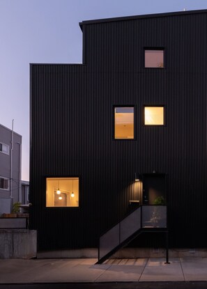 A modern building with a dark facade, multiple windows, and a staircase leading to an entrance. - Designer 2-Bed Loft in Art Museum Area w/ Patio (Philadelphia)