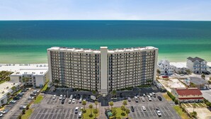 Un hôtel de grande hauteur doté d’une cour intérieure, d’un parking et offrant une vue sur la plage.