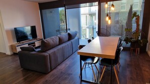 Una sala moderna con un sofá, una mesa de comedor y un televisor.