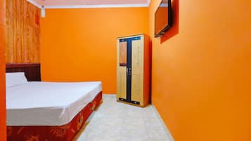A room with a bed, a wardrobe, and a television on the wall.