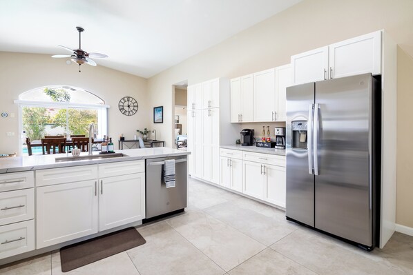 Enjoy cooking in this well-lit kitchen with a large island, dishwasher, and stainless steel refrigerator.