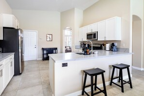 Enjoy cooking in this well-equipped kitchen with a central island, barstools, and ample counter space.