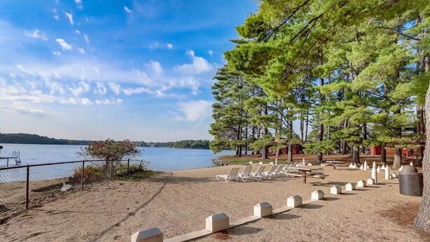 A beach area with sun loungers and a fenced swimming area. - Lake view 2 bedroom House on Lake Delton Resort. Beaches. Pool. Playground! (Lake Delton)